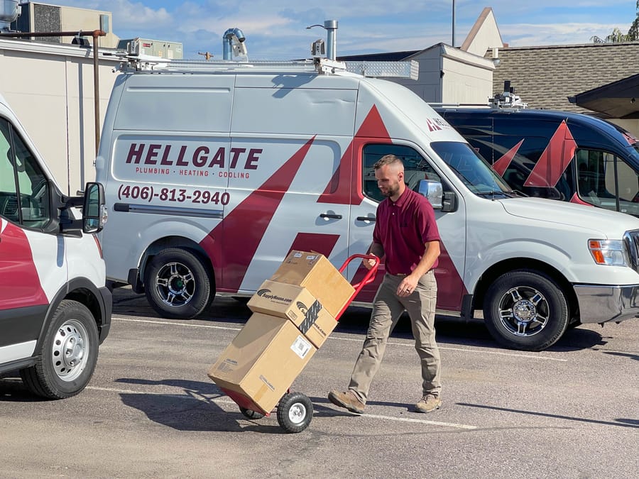 Hellgate employee carrying parts for AC replacement.