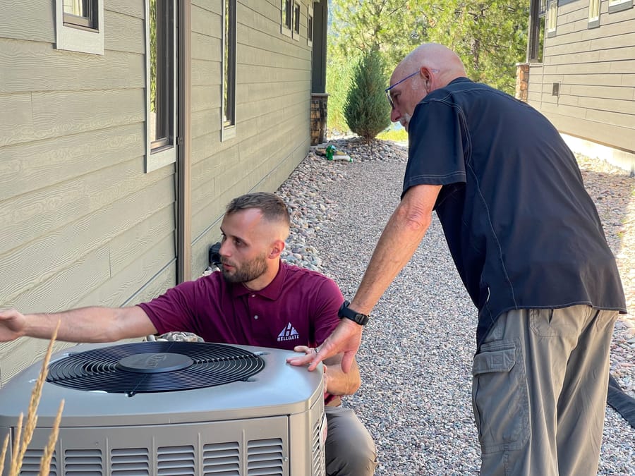 Two Hellgate HVAC techs conducting air conditioning services.