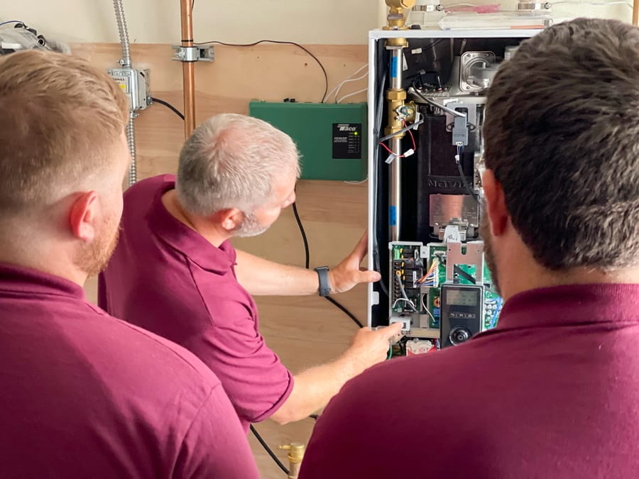 Hellgate employees conducting maintenance on open boiler system.