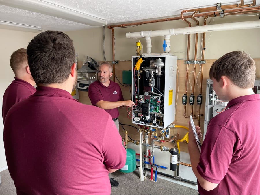 Hellgate employees surrounding an open boiler.