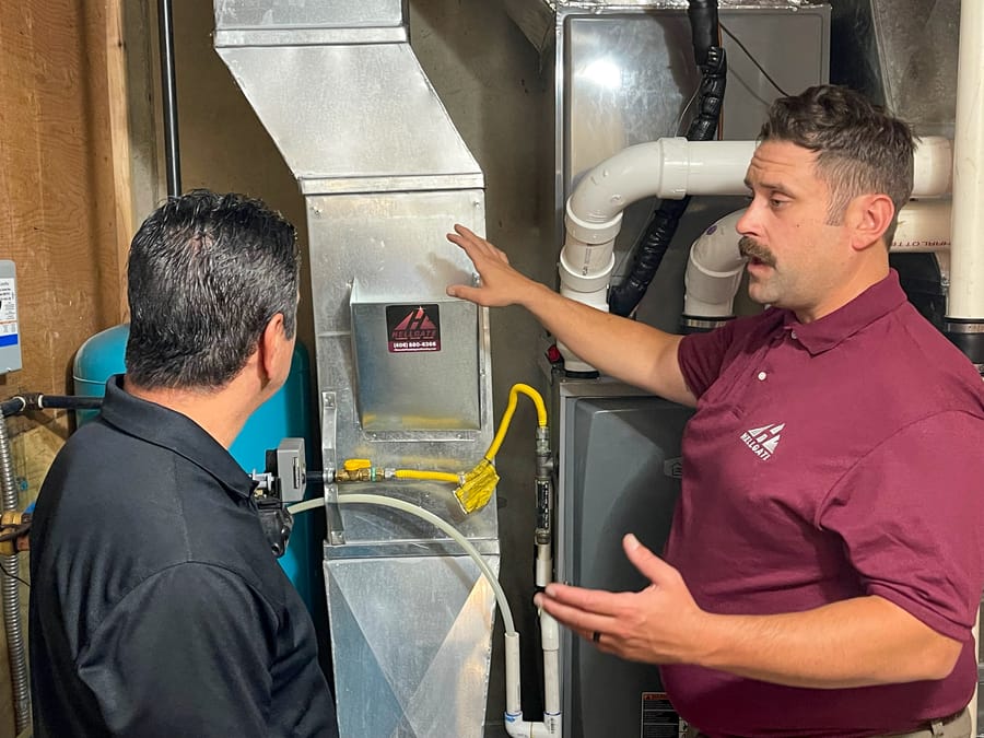 Hellgate employee explaining furnace maintenance to a client.