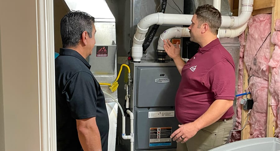Hellgate employee showing client a furnace replacement.