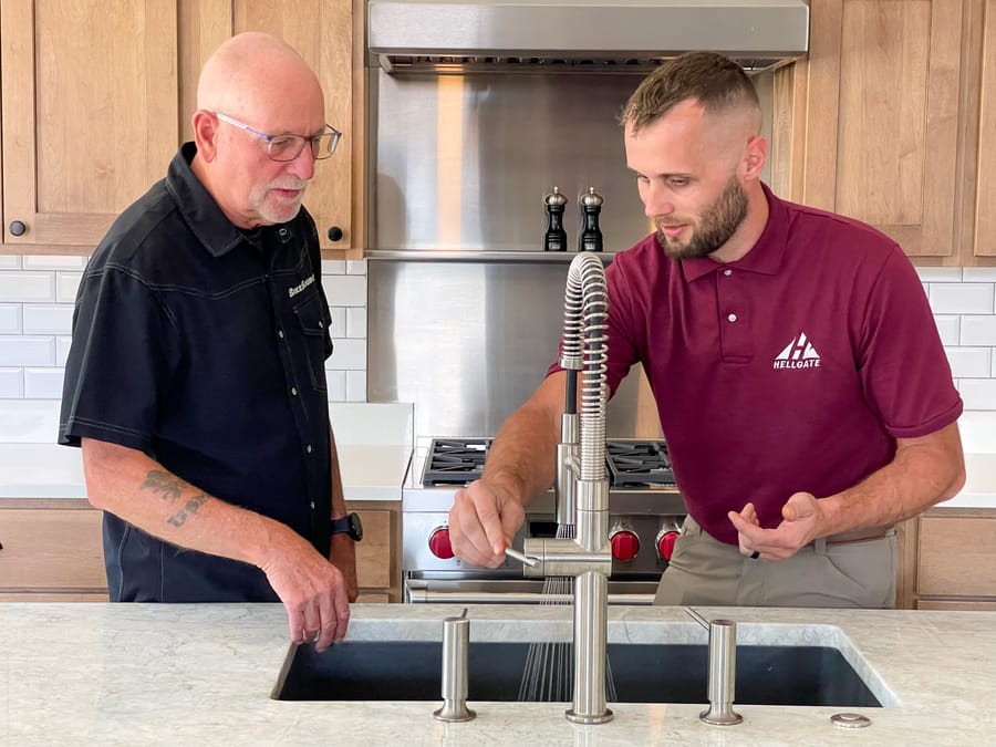 Hellgate plumber testing water pressure in kitchen sink.